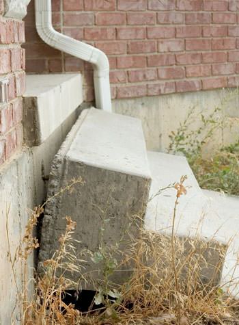 sinking outdoor concrete steps showing cracking and soil washout in Hazleton