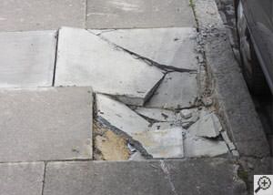 photo of a sinking concrete sidewalk with cracks in Bloomsburg