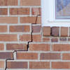 long jagged cracks starting at the corner of a window along a brick wall on a Hanover home