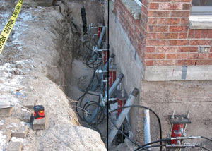 Foundation push piers installed around a house with a foundation settlement issues in Whitehall