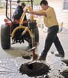 Digging a hole in the garage floor to make room for a wall anchor installation in Pottsville, Pennsylvania