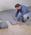 Contractors installing basement sub floor tiles and matting on a concrete basement floor in Scranton, Pennsylvania