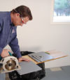 installing a waterproof vapor barrier on a basement floor to prepare for basement carpeting in a Allentown home